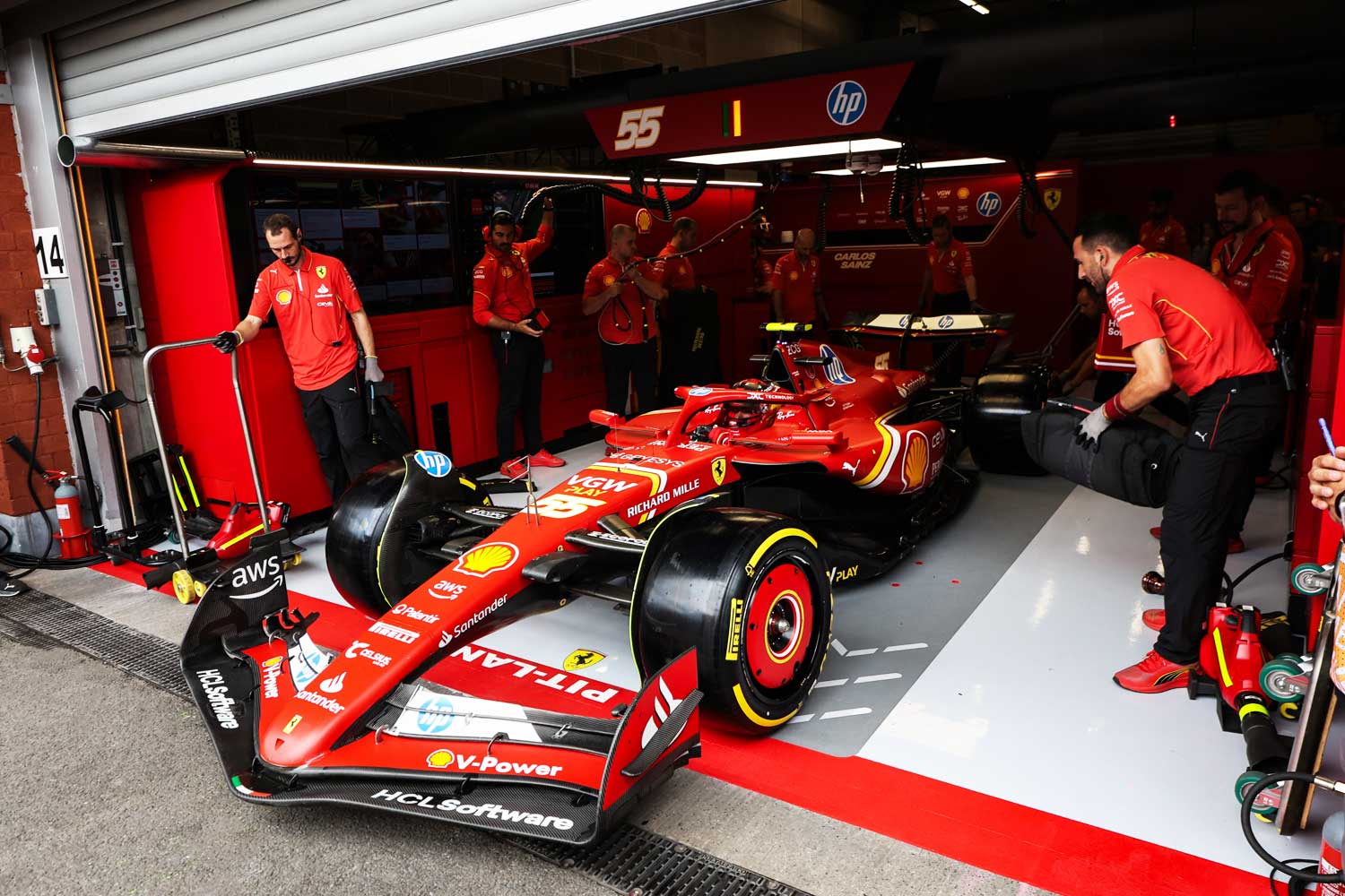 El Ferrari de Carlos Sainz en el box durante el GP de Belgica 2024 con el equipo preparado para el cambio de neumaticos